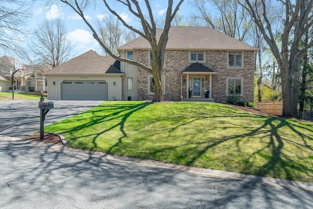 view of front of home featuring fence, an attached garage, brick siding, a front yard, and driveway