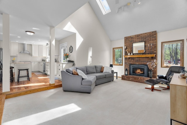 living area featuring a skylight, light carpet, and a wealth of natural light