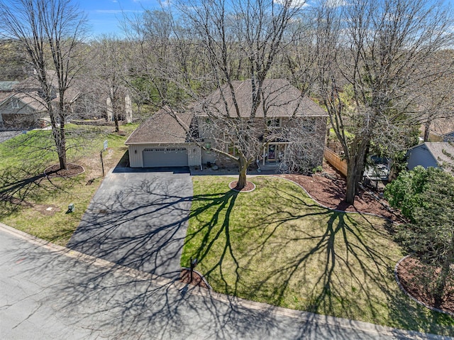view of front of property with an attached garage, a front yard, and aphalt driveway