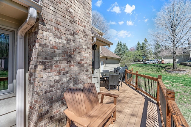 deck featuring a lawn and outdoor dining area