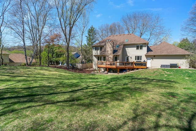 rear view of property featuring a lawn and a wooden deck