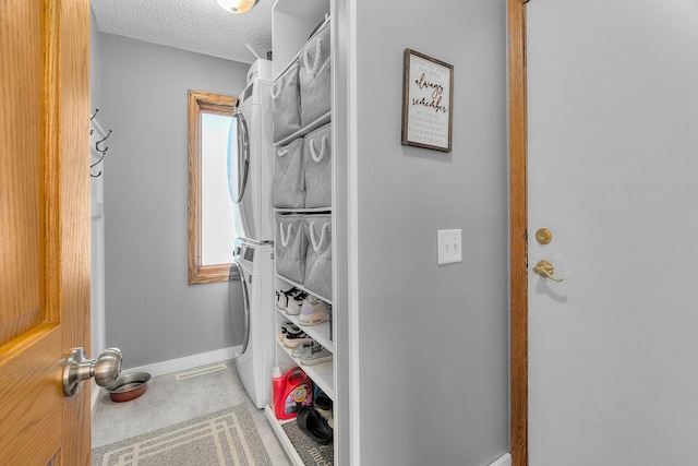 walk in closet with tile patterned flooring and stacked washer / drying machine