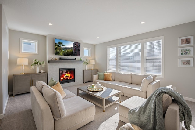 living room featuring a glass covered fireplace, baseboards, carpet flooring, and recessed lighting