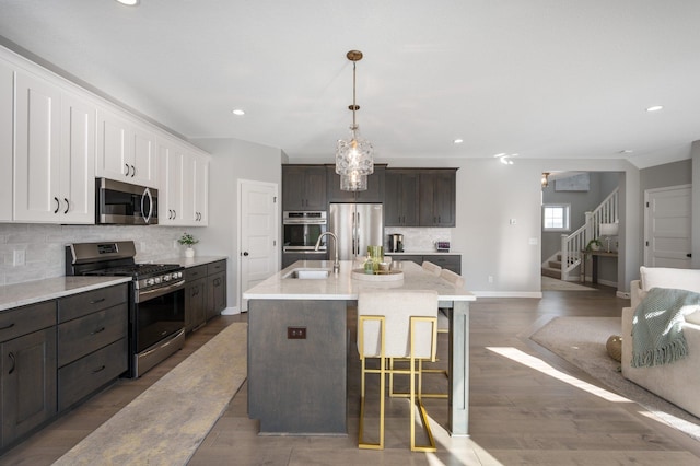 kitchen featuring a sink, stainless steel appliances, baseboards, recessed lighting, and tasteful backsplash