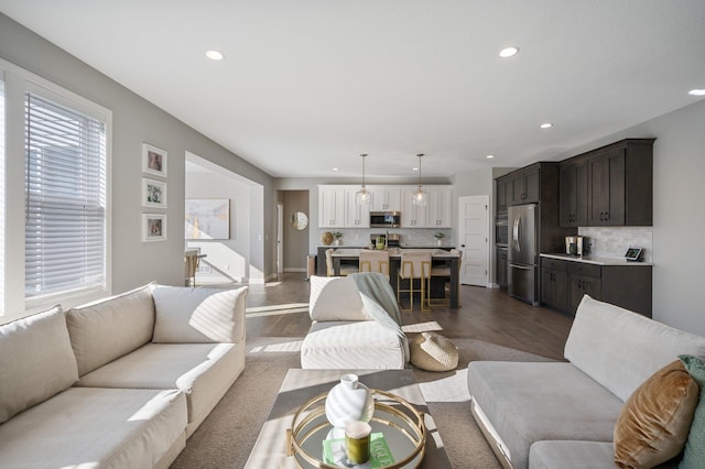 living area with recessed lighting, dark wood-style flooring, and baseboards