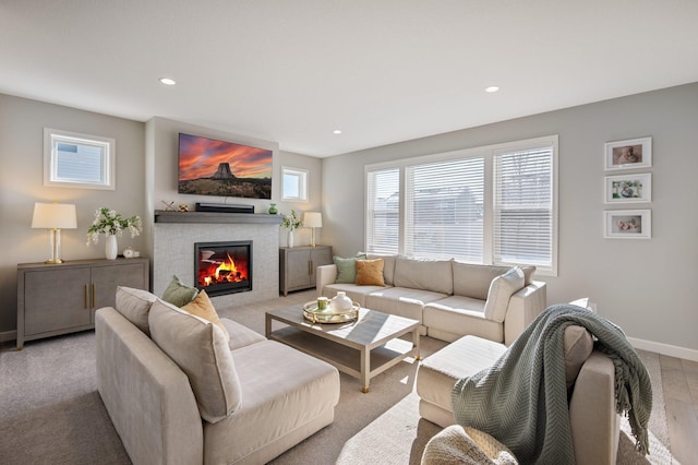 living area with baseboards, recessed lighting, and a tile fireplace