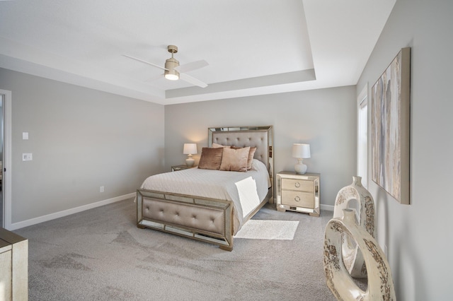 bedroom with carpet floors, baseboards, ceiling fan, and a raised ceiling
