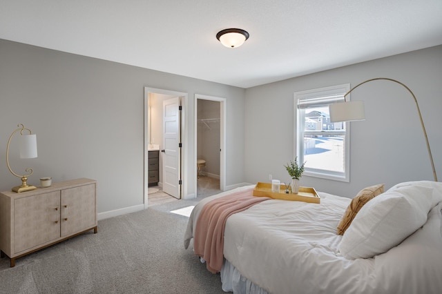 bedroom featuring baseboards, a closet, a spacious closet, and light carpet
