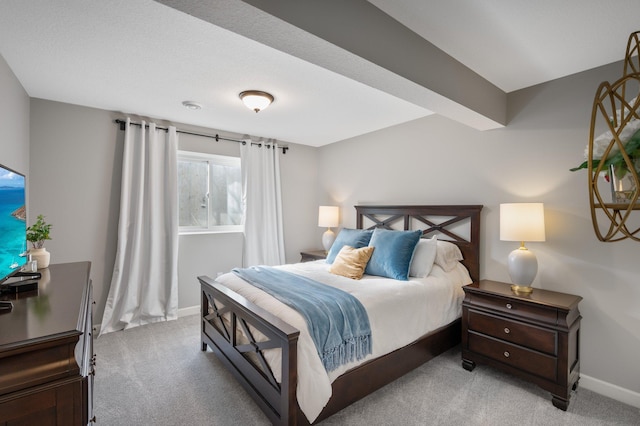 bedroom featuring baseboards and light carpet