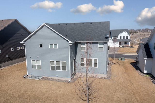 rear view of property with a shingled roof