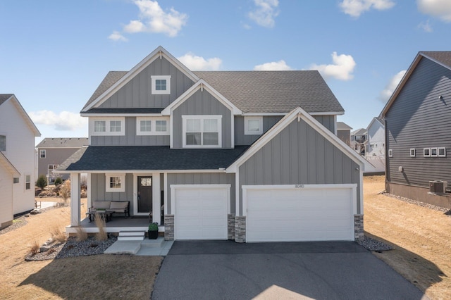 craftsman-style home featuring a porch, aphalt driveway, board and batten siding, and roof with shingles