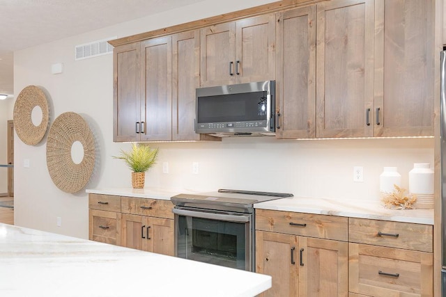 kitchen featuring light countertops, stainless steel appliances, and visible vents