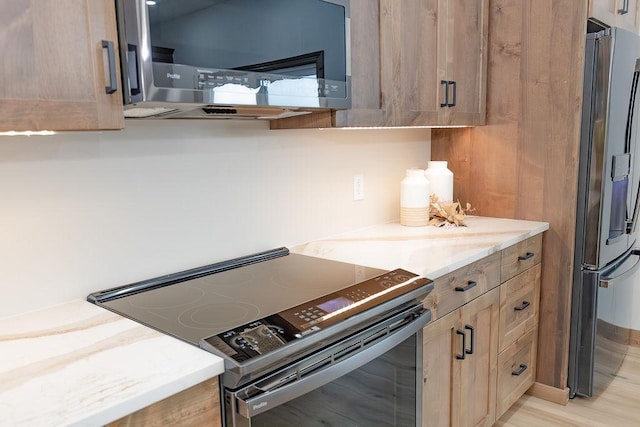 kitchen featuring light stone countertops and stainless steel appliances