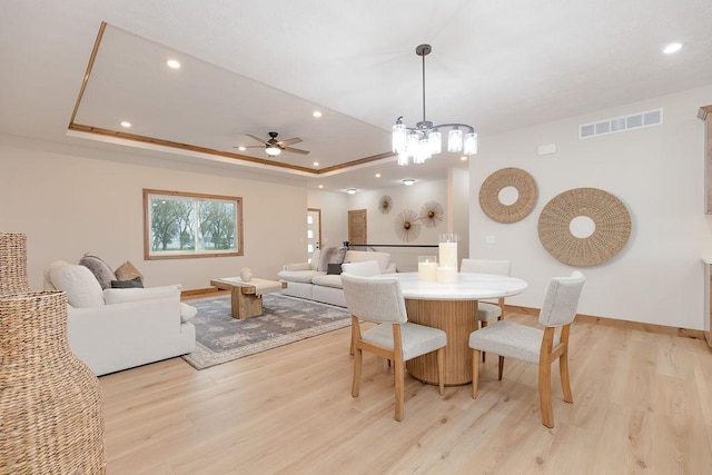 dining space featuring visible vents, a raised ceiling, baseboards, light wood-style floors, and recessed lighting