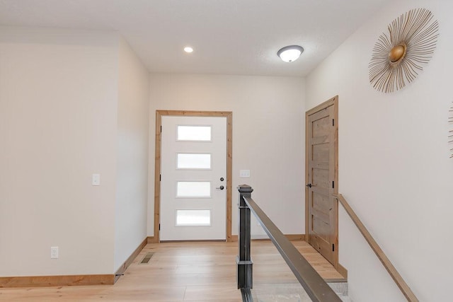 foyer entrance featuring recessed lighting, baseboards, light wood-type flooring, and visible vents