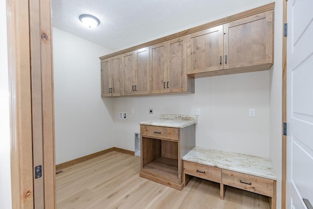 washroom featuring hookup for an electric dryer, light wood-type flooring, cabinet space, baseboards, and hookup for a washing machine