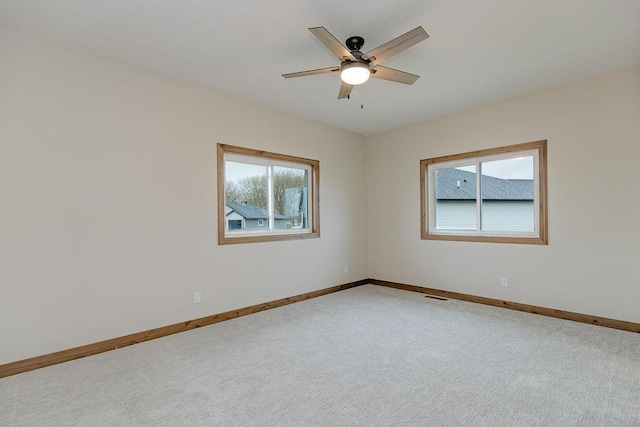 carpeted empty room featuring a ceiling fan, baseboards, and visible vents