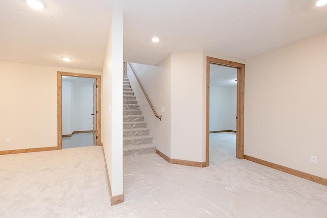finished below grade area with recessed lighting, carpet flooring, baseboards, and stairway