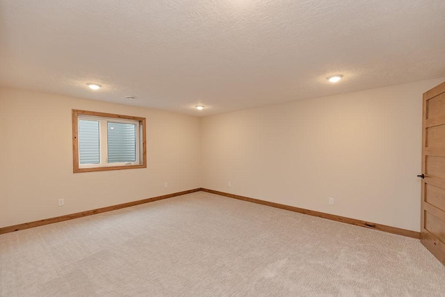 spare room featuring recessed lighting, baseboards, and light carpet