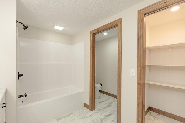 full bath with baseboards, toilet, a textured ceiling, and marble finish floor