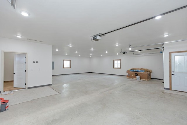garage with baseboards, a garage door opener, and electric panel