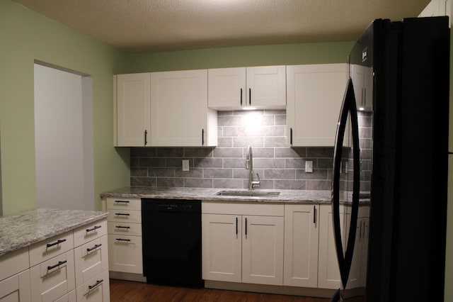 kitchen featuring black appliances, a sink, white cabinets, and decorative backsplash