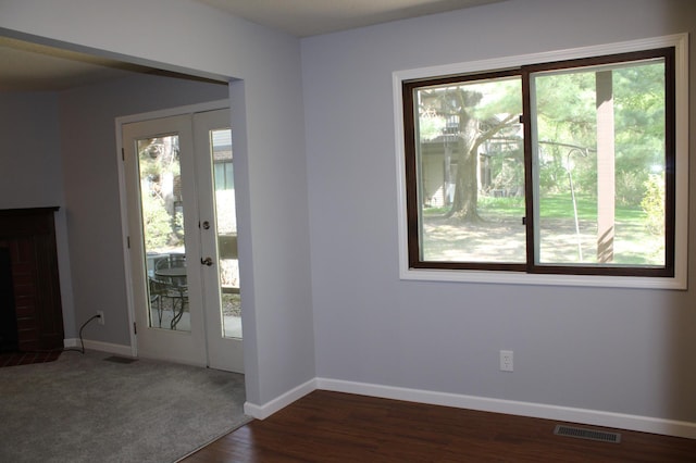 entryway with baseboards, french doors, a brick fireplace, and dark wood-style flooring