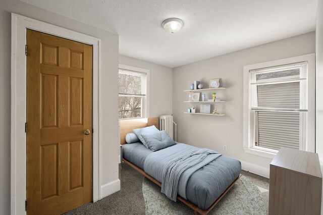 carpeted bedroom featuring baseboards and radiator