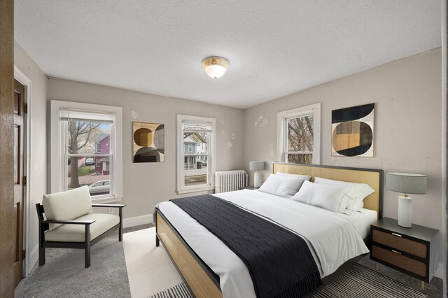 bedroom featuring baseboards, carpet flooring, radiator heating unit, and multiple windows