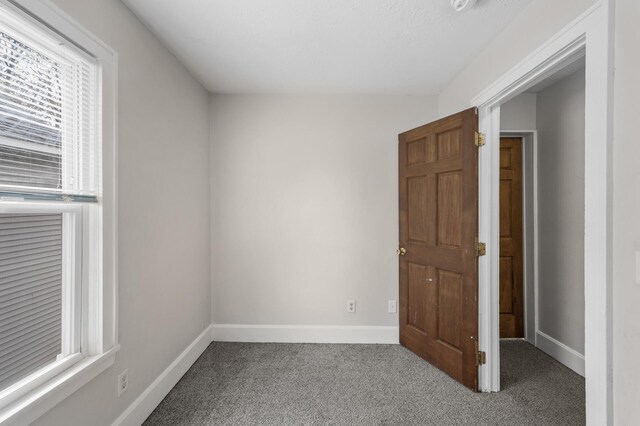 spare room featuring baseboards and carpet