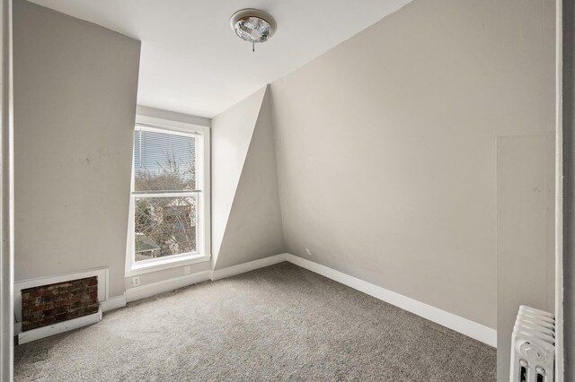 bonus room with baseboards, radiator heating unit, and carpet