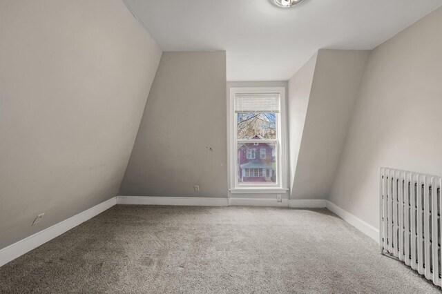 unfurnished room featuring carpet flooring, baseboards, and radiator