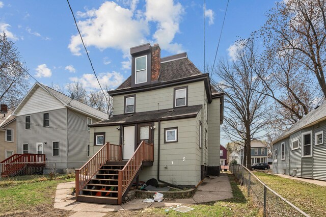 back of house with fence and roof with shingles