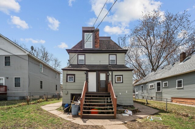 back of house with fence, a shingled roof, a chimney, and entry steps
