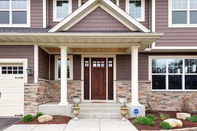 2919 Hilltop Dr, Chaska, MN 55318 - doorway to property featuring stone siding, a porch, and a garage