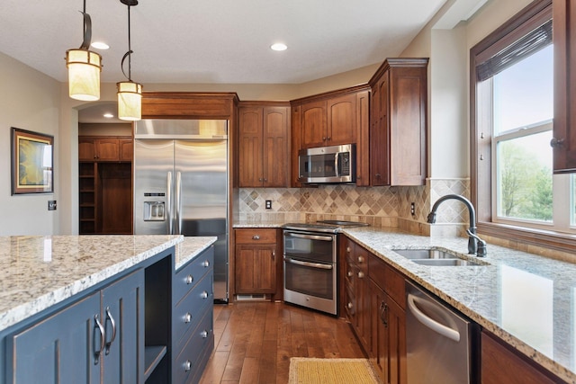 2919 Hilltop Dr, Chaska, MN 55318 - kitchen featuring appliances with stainless steel finishes, a sink, dark wood-type flooring, light stone counters, and recessed lighting