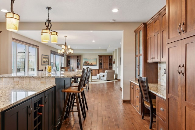 2919 Hilltop Dr, Chaska, MN 55318 - kitchen featuring a breakfast bar, dark wood-style floors, an office area, pendant lighting, and recessed lighting