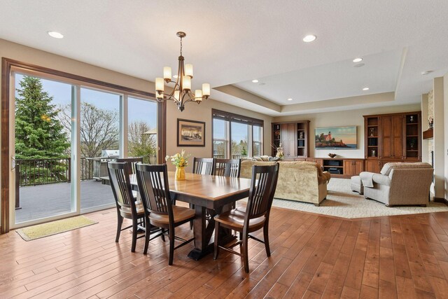 2919 Hilltop Dr, Chaska, MN 55318 - dining room featuring a tray ceiling, a chandelier, hardwood / wood-style flooring, and recessed lighting