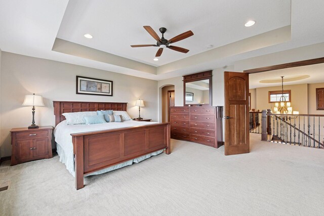 2919 Hilltop Dr, Chaska, MN 55318 - bedroom with light carpet, a tray ceiling, a chandelier, recessed lighting, and arched walkways