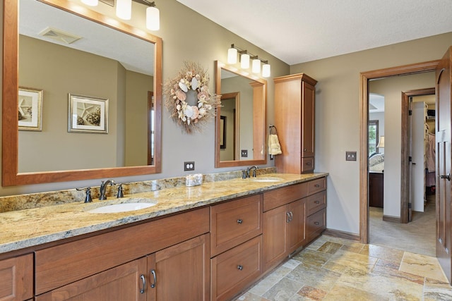 2919 Hilltop Dr, Chaska, MN 55318 - bathroom with stone finish flooring, double vanity, baseboards, and a textured ceiling