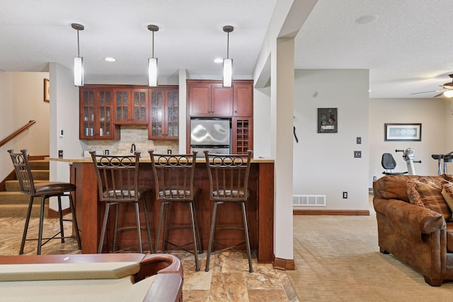 2919 Hilltop Dr, Chaska, MN 55318 - indoor wet bar featuring fridge, decorative light fixtures, decorative backsplash, light carpet, and baseboards