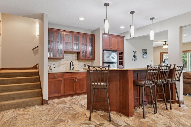2919 Hilltop Dr, Chaska, MN 55318 - kitchen featuring stainless steel refrigerator, a sink, a kitchen breakfast bar, a ceiling fan, and glass insert cabinets