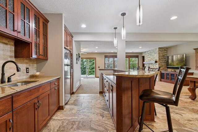 2919 Hilltop Dr, Chaska, MN 55318 - kitchen featuring a sink, open floor plan, a kitchen bar, glass insert cabinets, and backsplash