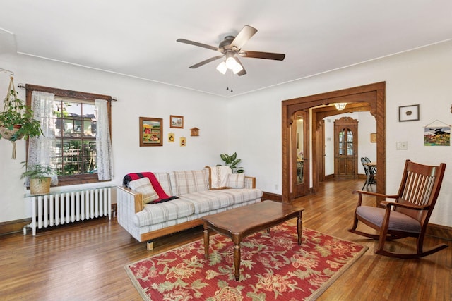 living room featuring radiator heating unit, wood finished floors, and healthy amount of natural light