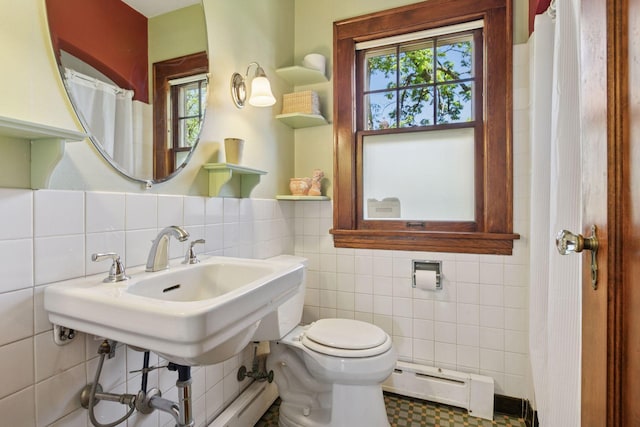 full bathroom with a baseboard heating unit, tile walls, and toilet