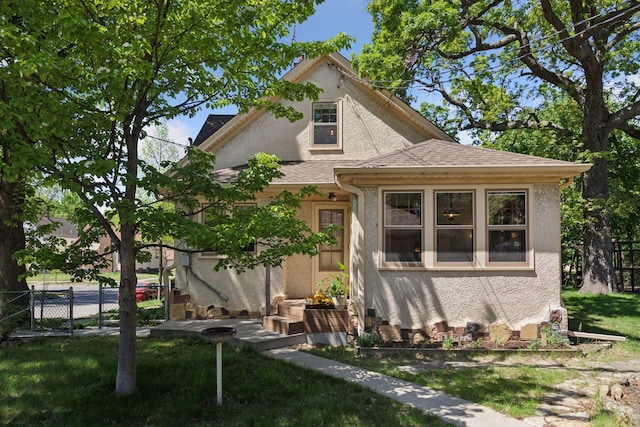 bungalow-style home with stucco siding and roof with shingles