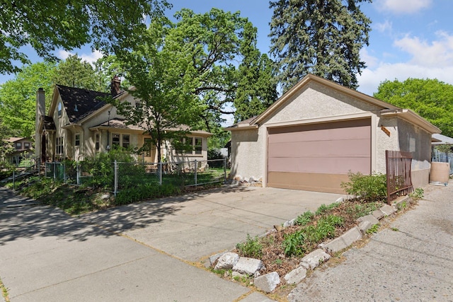 view of front of home with fence, driveway, and stucco siding
