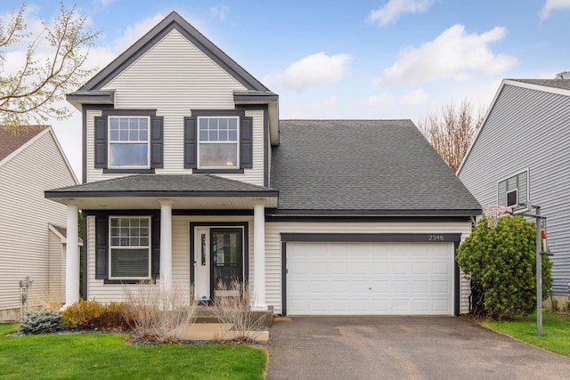 traditional home with a porch, driveway, a shingled roof, and a garage