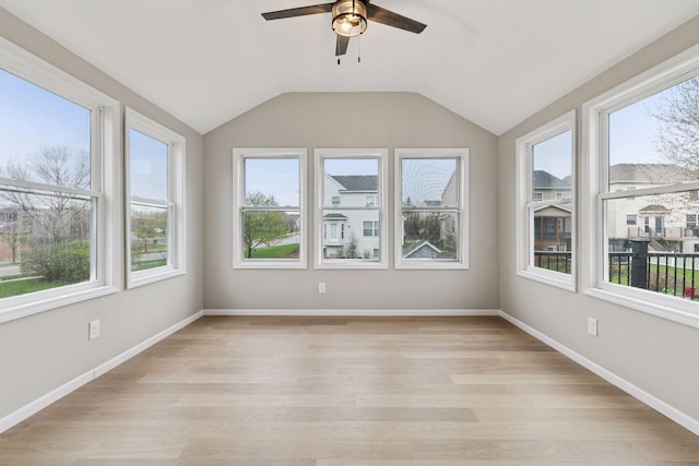 unfurnished sunroom with a healthy amount of sunlight, lofted ceiling, and wood finished floors