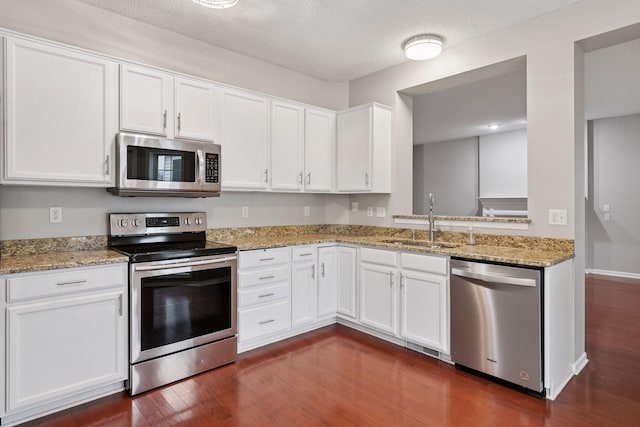 kitchen featuring a sink, white cabinetry, appliances with stainless steel finishes, and dark wood-style floors